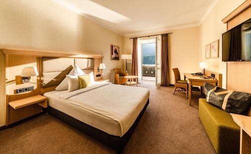 a hotel room with a bed and a desk at Eibsee Hotel in Grainau