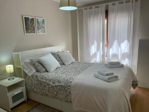 a bedroom with a white bed with towels on it at Apartamento Enol in Cangas de Onís