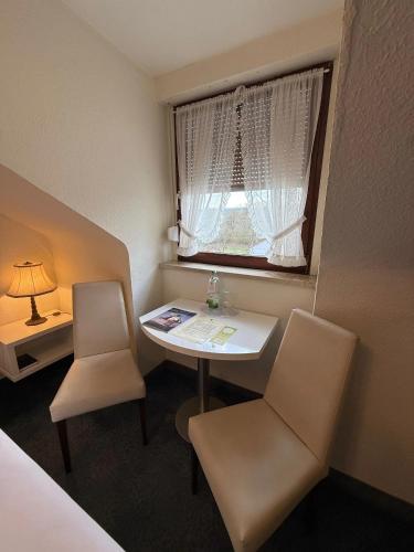 a room with a table and two chairs and a window at Hotel Löwen in Randersacker