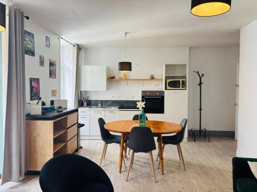 une cuisine et une salle à manger avec une table et des chaises dans l'établissement Appartement au coeur de la vieille ville, à Boulogne-sur-Mer