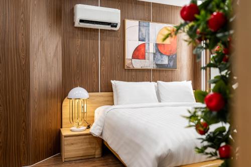 a bedroom with a bed and a night stand with a lamp at A Boi Apartment at District 3 in Ho Chi Minh City