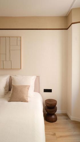 - une chambre avec un lit blanc et un tabouret en bois dans l'établissement Exceptional facing Palais Cannes1, à Cannes