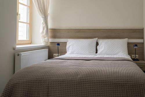 a bed with a checkered blanket in a bedroom at Birštono Banginukas poilsio namai in Birštonas