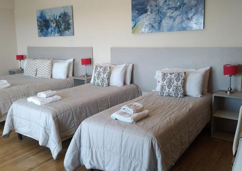a room with two beds with towels on them at Apart Hotel Quijote by DOT Suites in Ciudad Lujan de Cuyo