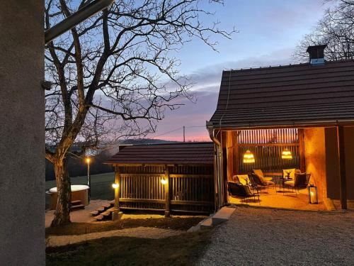a small cabin with a table and chairs and lights at Premium Gardenguesthouse Mlinar with Pool & Sauna in Fokovci