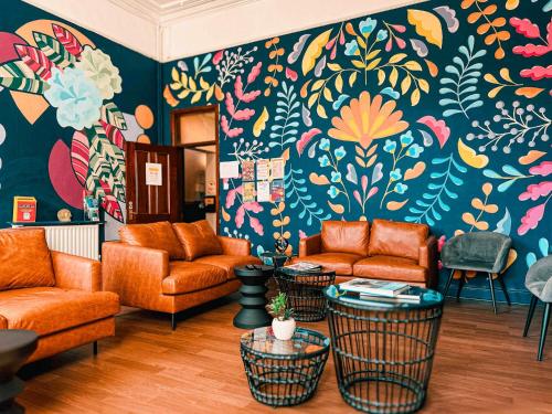 a living room with orange furniture and a colorful wall at Gardiner House Hostel in Dublin