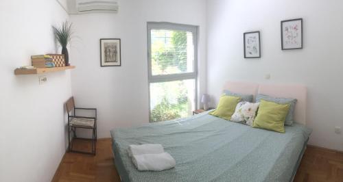 - une chambre avec un lit doté de draps verts et une fenêtre dans l'établissement Acacia Hill olive tree apartment, à Herceg-Novi