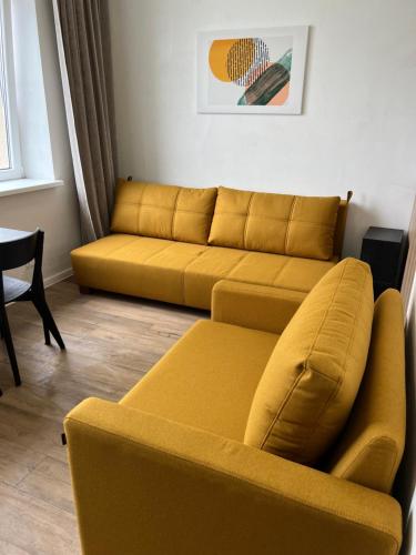 a living room with a yellow couch and a table at Air Apartments - Code entry only, No staff in Vilnius