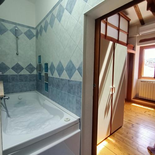 a bath tub in a bathroom with blue tiles at B&B Raggio di sole in Muggia
