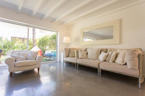 a living room with two couches and a mirror at FLH Melides Beach House in Melides