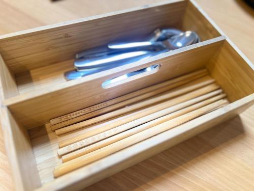 a wooden box with scissors and chopsticks in it at Prevoyance前原中央 in Itoshima