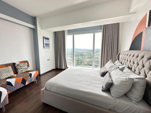 a bedroom with a large bed with a large window at Condotel Aeon Towers Davao 20mbps Wifi in Davao City