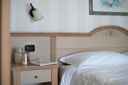 a bedroom with a bed and a nightstand next to a bed sidx sidx sidx at Hotel Mondial in Bellaria-Igea Marina
