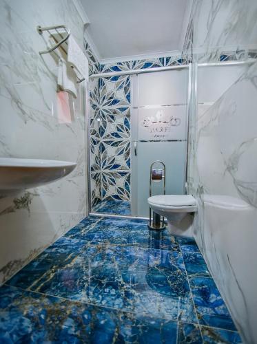 a bathroom with a blue and white tile floor and a toilet at Parfe Apart in Trabzon