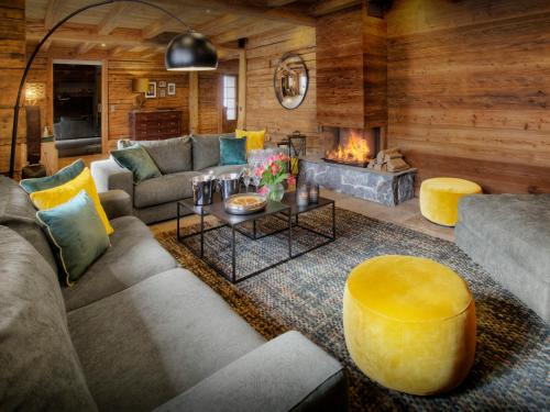 a living room with a couch and a fireplace at Chalet Goville - OVO Network in La Giettaz