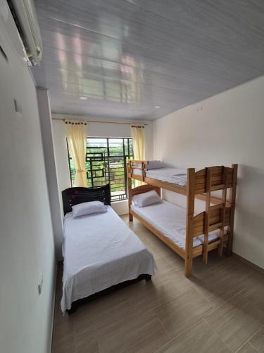a bedroom with two bunk beds and a window at Casa de Char Girardot, Nariño Cundinamarca in Nariño