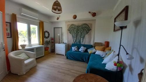 a living room with a blue couch and a chair at La cacarinette in Rayol-Canadel-sur-Mer