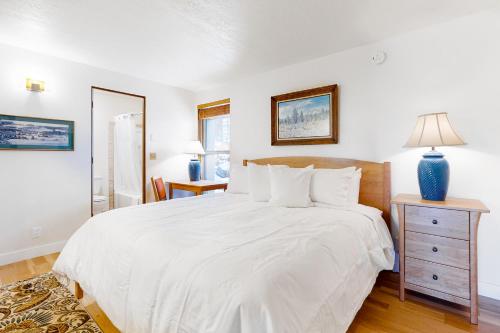 a white bedroom with a bed and a nightstand at Night at the Inn in Bend
