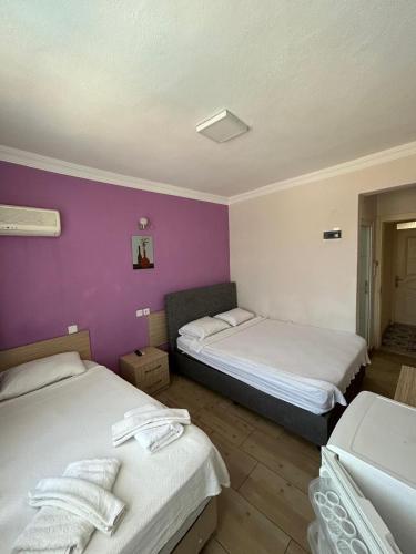 a room with two beds and a purple wall at Mut Apart Hotel in Fethiye