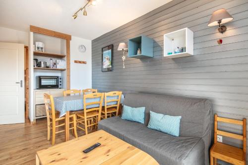 un salon avec un canapé et une table dans l'établissement Le Robero - proche dune station de ski, à Chamrousse