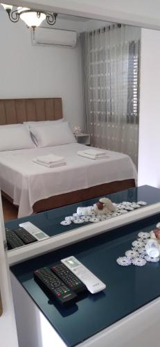 a room with a bed and a desk with a computer keyboard at Vila Nela in Shkodër