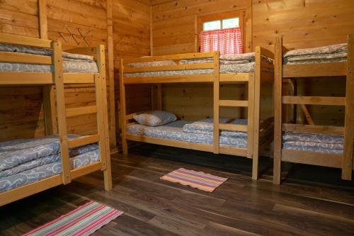 a room with three bunk beds in a cabin at Grand Tara Rafting Resort in Foča