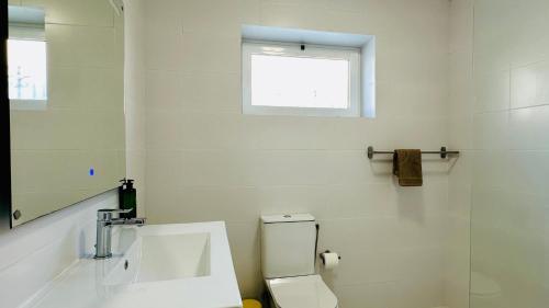a bathroom with a toilet and a sink and a window at Vital by Check-in Portugal in Albufeira