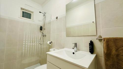 a white bathroom with a sink and a shower at Vital by Check-in Portugal in Albufeira
