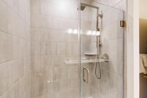 a shower with a glass door in a bathroom at The Peninsula --- 22308 Dune Cir 74 in Millsboro