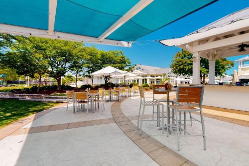 a group of tables and chairs under an umbrella at The Peninsula --- 22308 Dune Cir 74 in Millsboro