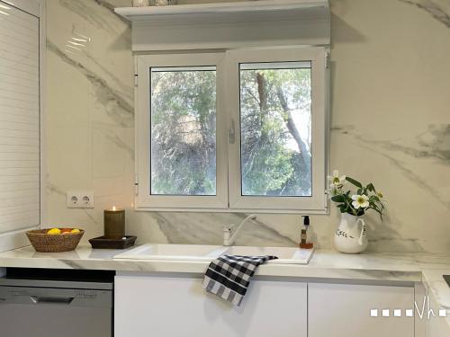 a white kitchen with a sink and a window at VH CostaBlanca - MIRASOL in Fanadix