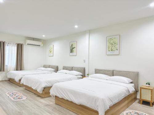 three beds in a room with white walls at Midori Haus-7mins to LeeGarden in Hat Yai