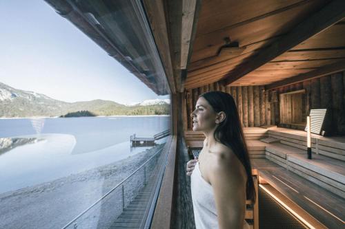 a woman standing on the side of a boat at Eibsee Hotel in Grainau