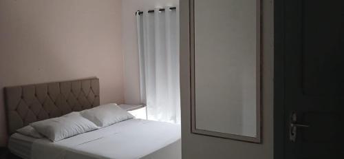 a bedroom with a bed with a mirror and a window at Acacia hotel in Laguna