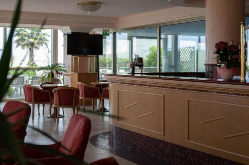 a bar in a restaurant with a table and chairs at Hotel Mondial in Bellaria-Igea Marina