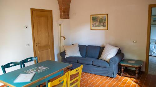 a living room with a blue couch and a table at Agriturismo La Ca'Solare in Palaia