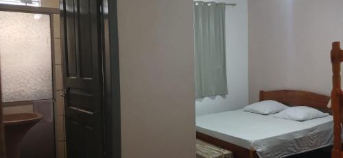 a small bedroom with a bed and a window at Acacia hotel in Laguna