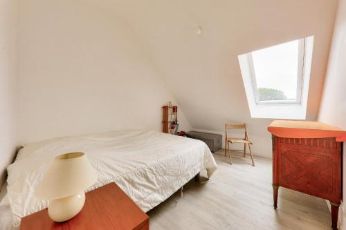 a bedroom with a bed and a table and a window at Belle maison pour 6 - 700m Plage de Penvins in Sarzeau