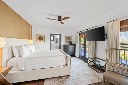 a bedroom with a white bed and a television at Iris Inn and Cabins in Waynesboro