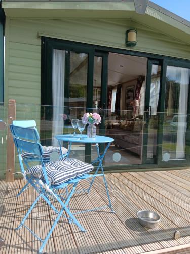 a blue table and a chair on a deck at Foxgloves and Ivy in Cockermouth