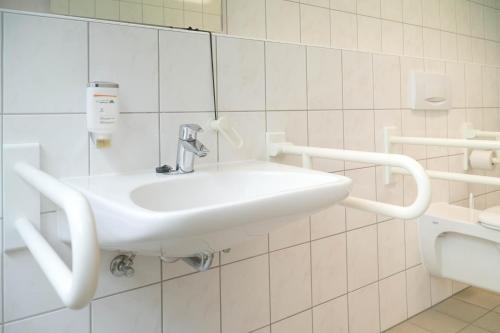 a bathroom with a white sink and a mirror at DJH Jugendherberge Dresden - Jugendgästehaus in Dresden
