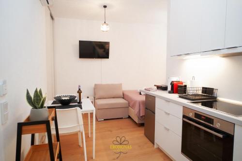 a kitchen and living room with a couch and a table at Erodionas Serenity - Corfu Town Studio in Agios Rokkos