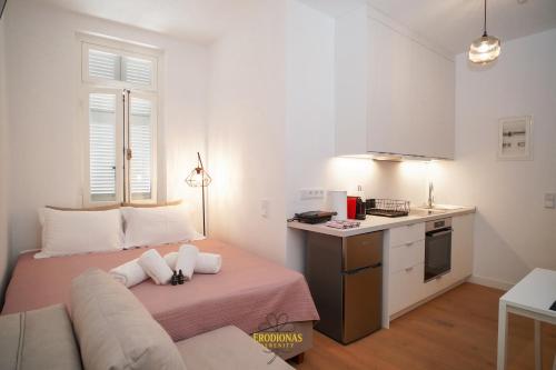a living room with a couch and a kitchen at Erodionas Serenity - Corfu Town Studio in Agios Rokkos