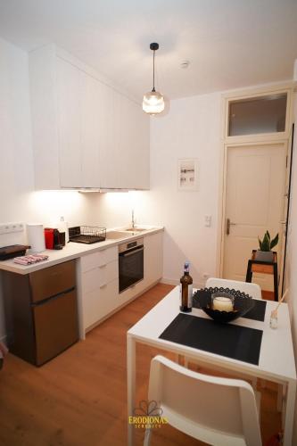 a kitchen with white cabinets and a white counter top at Erodionas Serenity - Corfu Town Studio in Ágios Rókkos