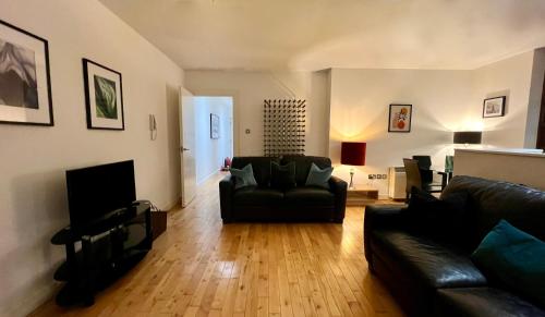 a living room with a couch and a television at Beautiful Loft City Centre, Liverpool 1 in Liverpool