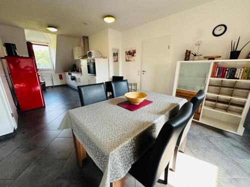 a dining room with a table and chairs and a kitchen at Gocher Berghof Ferienwohnungen Langanke in Goch