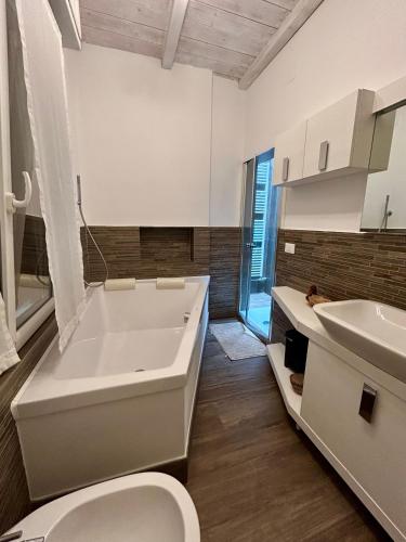 a bathroom with a tub and a toilet and a sink at A Casa di Lamu, eleganza in Piazza della Vittoria, 140mq in Pavia