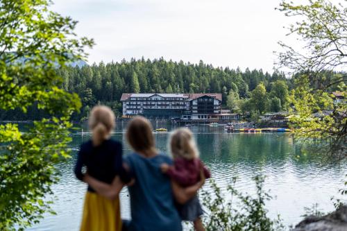 a group of three women standing by a lake at Eibsee Hotel in Grainau