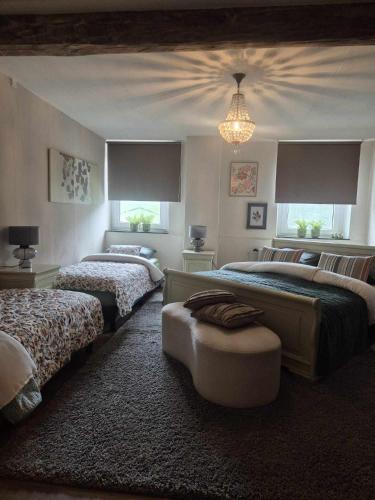 a bedroom with two beds and a chandelier at Boerderijwoning in Maastricht