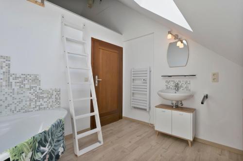 a white bathroom with a sink and a mirror at Cottage Fauna & Flora in Malmedy